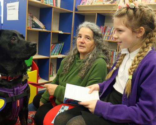 11 year old Amy reads to reading dog Lunar watched by owner Jane Baxter