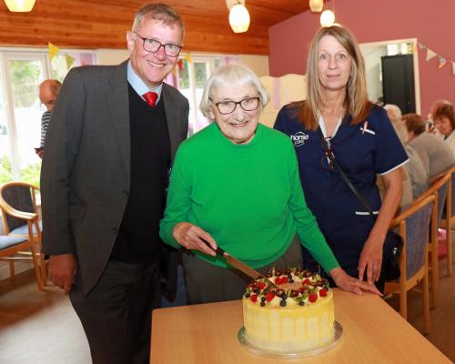 Ida Innes cuts the celebratory cake at Harriet Court watched by Michael Newey and Joanne Grimes sm