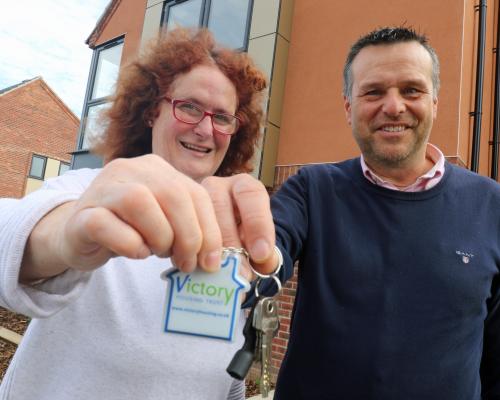 Victory Housing Trust development director Mark Burghall hands the keys to the 1000th new home to Jane Craske