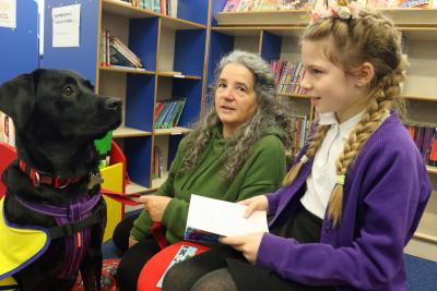 11 year old Amy reads to reading dog Lunar watched by owner Jane Baxter