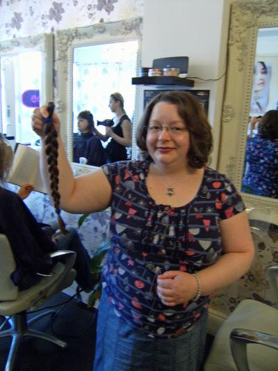 Anna McKay holding the hair she is donating to the Little Princess Trust