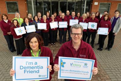 Anne Newton and Johh Archibald with members of Victory Housing Trust staff who have become Dementia Friends