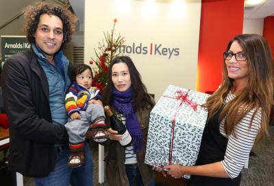 Chris and Yuki Russell with baby Toki receive their case of wine from Elisha Mace of Arnolds K eys