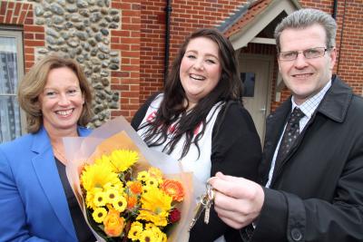 Jade Gomer centre receives the keys to her new flat from John Archibald and a bunch of flowers from Clare Barter