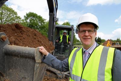 John Archibald aided by Ian Reeve of EN Suiter Sons in the digger cuts the first sod at School Close Ludham