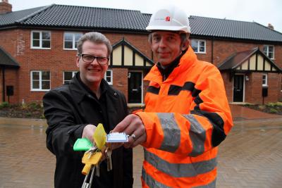 John Archibald of Victory Housing Trust left receives the keys to new homes in Cromer from Martin Weavers of Norfolk Homes