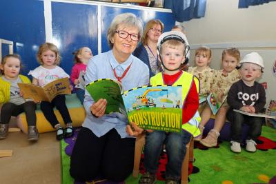 Maggie Abel of Abel Homes reads a book about construction with four year old Leyton at Little Acorns in Watton sm