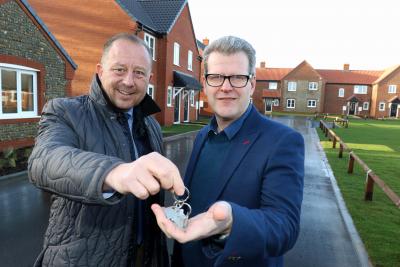 Paul Pitcher left of Wellington hands over the keys to new homes at Bacton to John Archibald of Victory Housing Trust sm