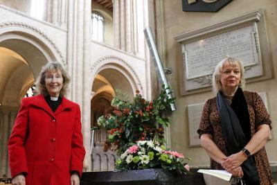 Rev Heather Knight left and Vision Norfolk chief executive Gina Dormer place flowers by the Thomas Tawell memorial in Norwich Cathedral sm