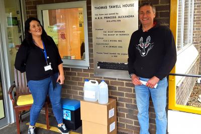 Samantha Capper manager at Thomas Tawell House receives the hand sanitiser from Patrick Saunders of Black Shuck