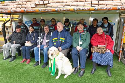 The group of visually impaired City fans from the NNAB testing out the dugout at Carrow Road sm