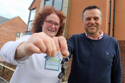 Victory Housing Trust development director Mark Burghall hands the keys to the 1000th new home to Jane Craske